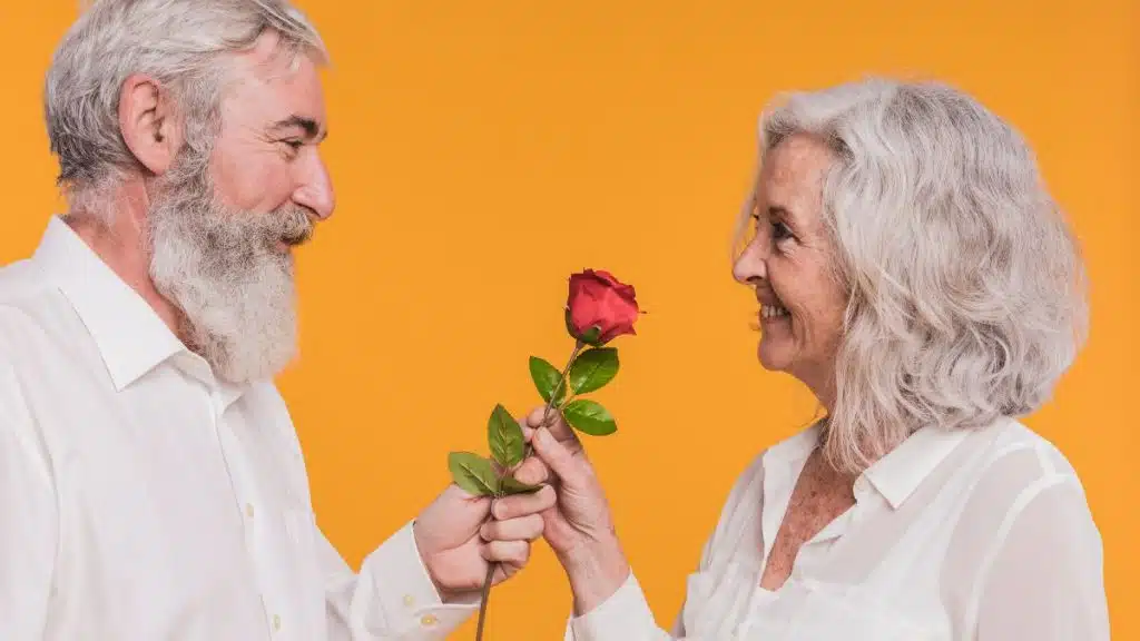 aniversare-40-ani-casatorie-cuplu-in-varsta-trandafir-rosu-fundal-portocaliu